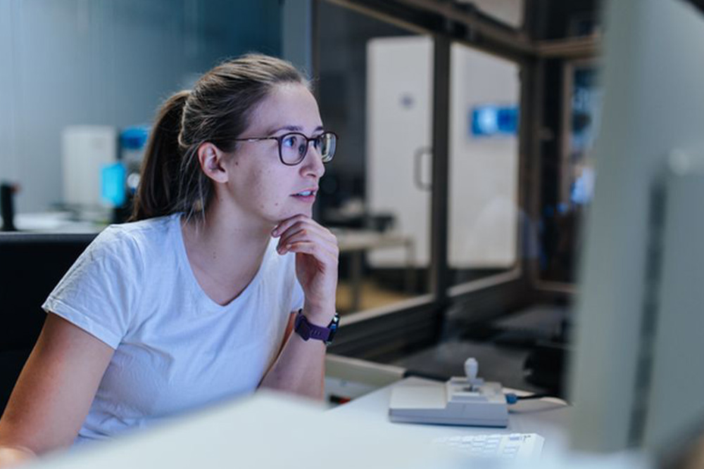 Eine junge Frau arbeitet gerade an ihrem Computer.